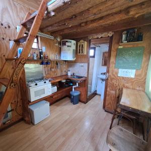 a kitchen with a stove and a ladder in a room at Cabaña El Carpintero in El Chalten
