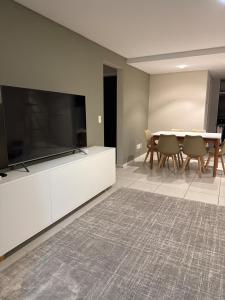 a living room with a large television and a table at Apartamento Novo no Centro de Pomerode in Pomerode