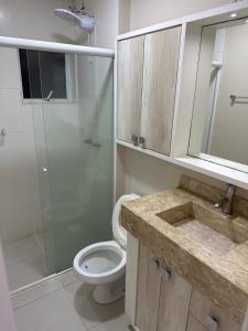 a bathroom with a toilet and a glass shower at Apartamento Novo no Centro de Pomerode in Pomerode +3 photos