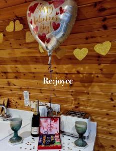 a heart balloon and a bottle of wine on a counter at Forester's Retreat Glamping - Dinas View - Vaccinated dogs over the age of 2 are accepted in Aberystwyth