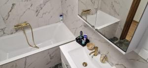 a white bathroom with a sink and a mirror at Apartamenty Retro Loft in Chorzów