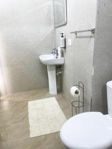 a bathroom with a white sink and a toilet at Vila Hysaj in Kamëz