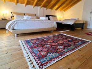a bedroom with two beds and a rug on the floor at Vila Hysaj in Kamëz