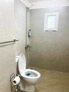 a bathroom with a toilet and a window at Vila Hysaj in Kamëz +20 photos