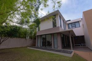 a large white house with large glass windows at Dream Living - Free GYM & Swimming Pool in Jodoh