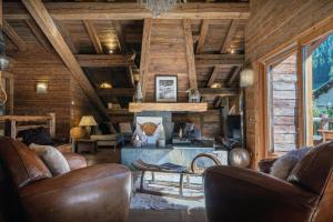 a living room with leather furniture and a fireplace at Chalet Patagonia - OVO Network in La Clusaz +18 photos