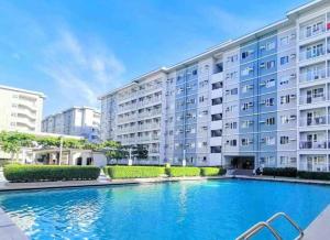 a large swimming pool in front of a building at Trees Residences Staycation in Manila