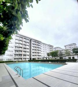 a large apartment building with a large swimming pool at Trees Residences Staycation in Manila +5 photos