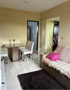 un salon avec un canapé et une table dans l'établissement Apartamento para COP 30, à Ananindeua