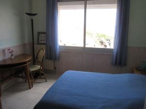 une chambre avec un lit, une table et une fenêtre dans l'établissement Sète chambre d'hôtes belle vue le quartier haut, à La Celle-sous-Gouzon