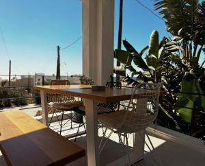 Una mesa y sillas de madera en un balcón. en AELIA Tinos, en Tinos