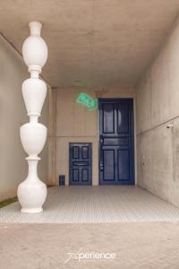 Eine weiße Vase steht vor einer blauen Tür. in der Unterkunft Sunflower at 12, City Views and Wonderland Vibes! in Hatillo + 39 Fotos