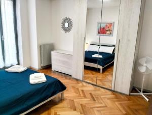 1 Schlafzimmer mit einem Spiegel, einem Bett und einem Bett sidx sidx sidx in der Unterkunft Appartamento di Marilù in Verbania