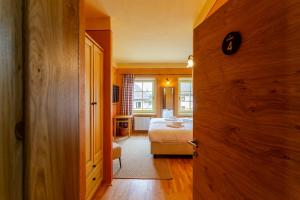 a room with a bed and a room with a door at Pod Gora Boutique Hotel in Kranjska Gora +17 photos