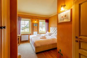 a bedroom with a bed and two windows at Pod Gora Boutique Hotel in Kranjska Gora
