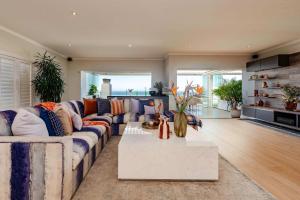 Villa Infinity Plettenberg Luxury Ocean View في بليتنبيرغ باي: غرفة معيشة مع أريكة وطاولة