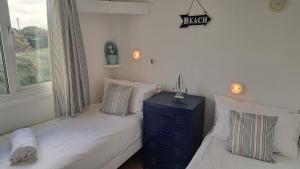 a bedroom with two twin beds and a window at F71 Elova, Riviere Towans in Hayle