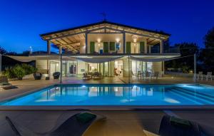 a house with a swimming pool in front of a house at Villa Montefalcone 8 by Marche Holiday Villas in Acqualagna