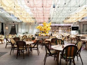 a restaurant with tables and chairs in a room at Novotel Atria Nimes Centre in Nîmes