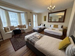 a living room with two beds and a mirror at Victoria Guest Accommodation & Studio Apartments in Pwllheli