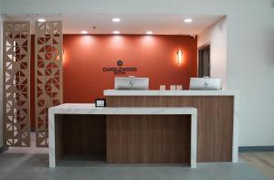 a lobby with two laptops on a counter with a red wall at Candlewood Suites Houston Space Center - Webster in Webster