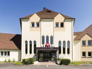 a large white building with a stop sign on it at Ibis Château-Thierry in Essômes-sur-Marne