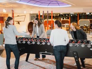 un groupe de personnes debout autour d'une table de ping-pong dans l'établissement Hôtel Mercure Lille Aéroport, à Lesquin