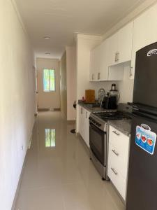 a kitchen with white cabinets and a black refrigerator at This home is paradise in Boca Chica +3 photos