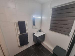 a white bathroom with a sink and a mirror at Le Cosy 4 de Disney Land paris in Noisy-le-Grand +15 photos