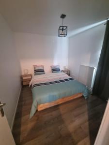 a bedroom with a bed in a white room at Le Cosy 4 de Disney Land paris in Noisy-le-Grand