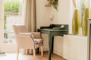 a chair and a desk in a room with a window at Vakantiehuisje met ruime tuin en hottub in Ouddorp
