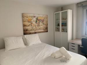 a bedroom with a white bed with a map on the wall at Residencial La Loma in Águilas +22 photos