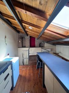 a kitchen with a blue counter top and wooden ceilings at Viola House in Viterbo