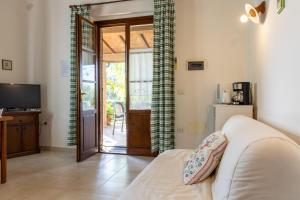 a living room with a bed and a sliding glass door at Agriturismo Arcobaleno in Bagno Roselle