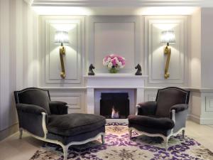 un salon avec deux chaises et une cheminée dans l'établissement Grand Hôtel Roi René Aix - MGallery Collection, à Aix-en-Provence 102 autres photos