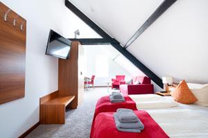 a attic bedroom with two beds and a tv at Hotel Das Kemperdick in Erkrath