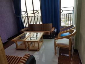 a living room with couches and a table and chairs at GC Hotel & Banquet Hall in Dargai