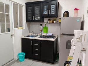 a kitchen with a sink and a refrigerator at Cómoda Habitación privada in Playa del Carmen