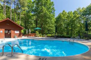 a large swimming pool in a yard with a cabin at Our Neck of the Woods at Hidden Lake in Nebo