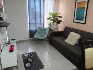 a living room with a couch and a chair at Cómoda Habitación privada in Playa del Carmen