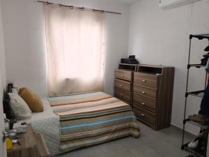 a bedroom with a bed and a dresser and a window at Cómoda Habitación privada in Playa del Carmen