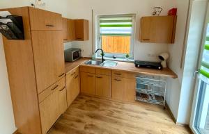 a kitchen with wooden cabinets and a sink and a window at RainValley Apartment in Ramspau