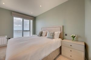 een slaapkamer met een groot bed en een groot raam bij Harbour Heights Seahouses in Seahouses