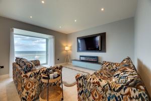 een woonkamer met twee banken en een groot raam bij Harbour Heights Seahouses in Seahouses