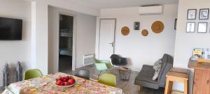 ein Wohnzimmer mit einem Tisch mit einer Obstschale darauf in der Unterkunft Le Jardin de Lucette in Le Rouret