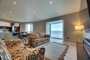 een woonkamer met banken en uitzicht op de oceaan bij Harbour Heights Seahouses in Seahouses