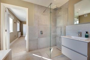 een badkamer met een glazen douche en een wastafel bij Harbour Heights Seahouses in Seahouses +24 foto's