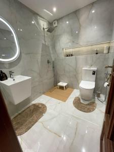 a white bathroom with a sink and a toilet at Résidence Ryad Albahr Herhoura in Temara