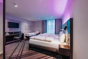 a hotel room with a large bed and a desk at Premier Inn Rosenheim City Lokhöfe in Rosenheim +26 photos