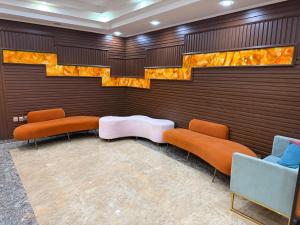 sala de estar con mesa y sillas de color naranja y azul en The Grand Mirage Hotel, en Ma‘ābīlah